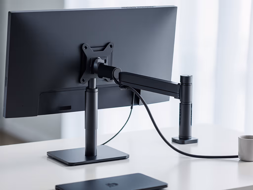 vesa-mounted_dock_behind_monitor_showing_clean_cable_routing_through_arm